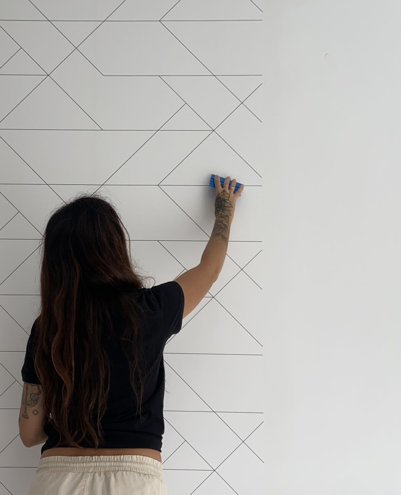 Instaladora aplicando papel pintado con estampado geométrico