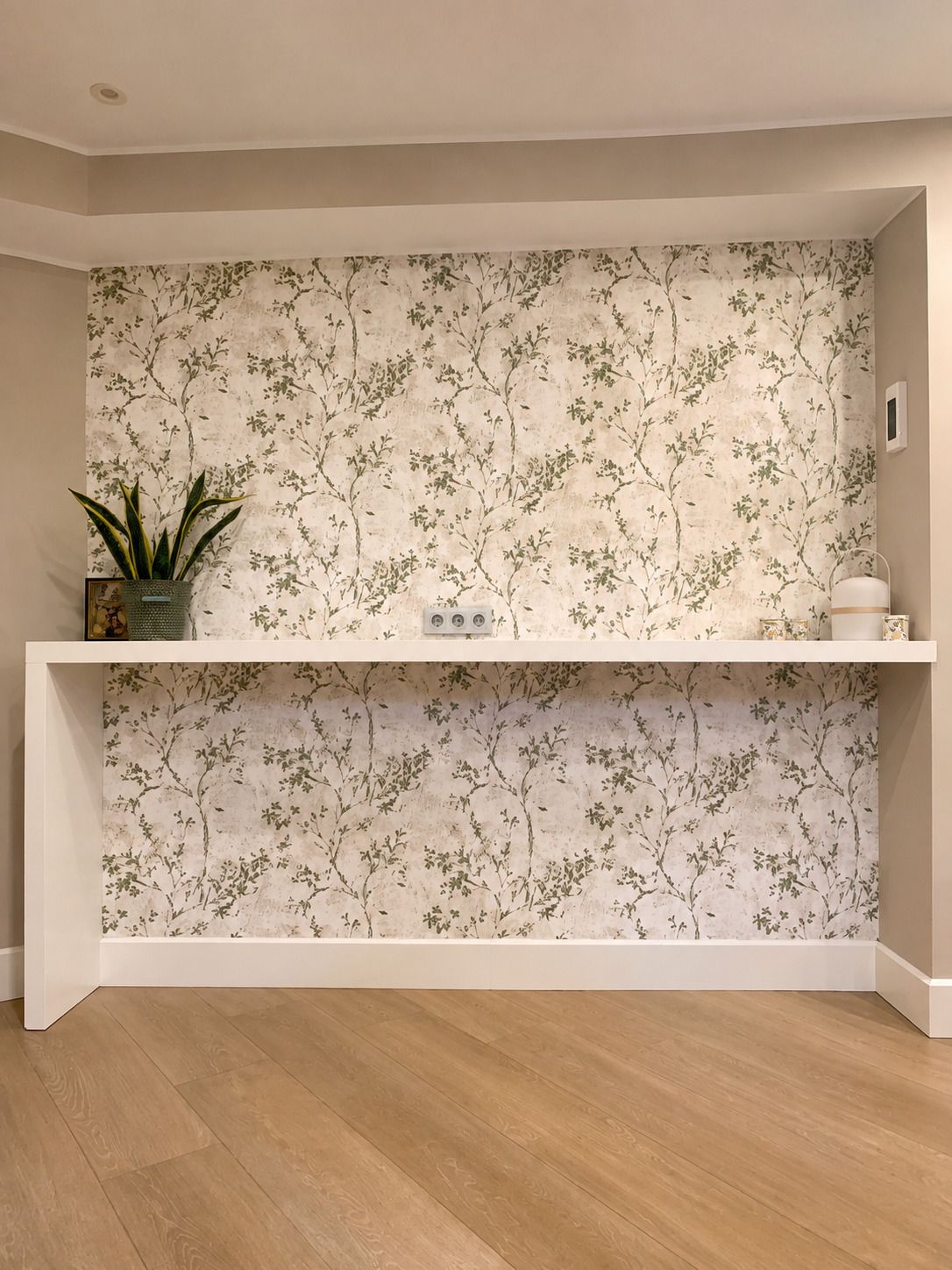 Papel pintado floral verde y beige junto a mueble de cocina