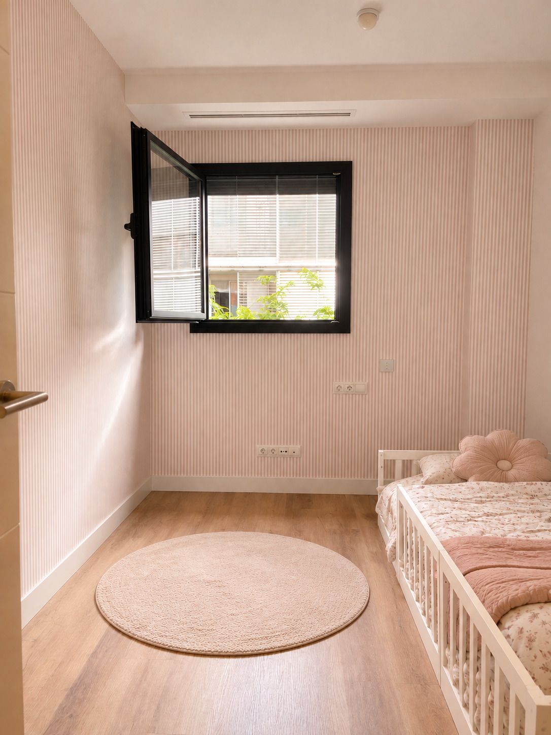 Papel pintado a rayas rosas en habitación infantil
